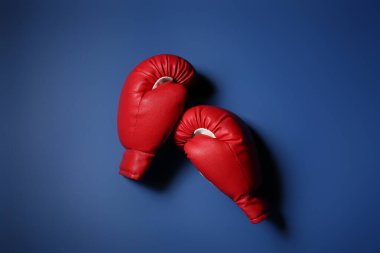 Mavi arka planda bir çift kırmızı boks eldiveni