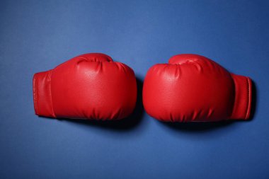 Mavi arka planda bir çift kırmızı boks eldiveni