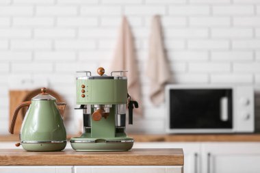Mutfak tezgahında elektrikli çaydanlık olan modern kahve makinesi.