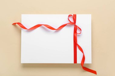 Bej arka planda kırmızı fiyonklu boş kart