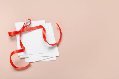 Kahverengi arka planda kırmızı fiyonklu boş kartlar