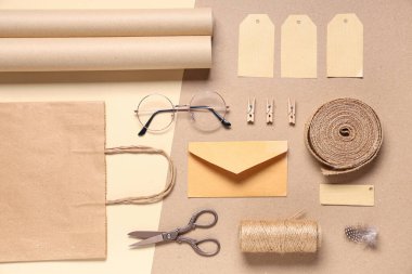 Bej arka planda gözlük, sicim, makas ve teslimat kağıdı içeren kompozisyon