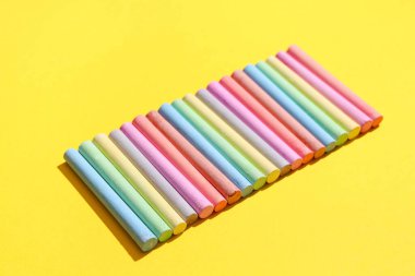 Sarı arkaplanda renkli tebeşir parçaları olan kompozisyon, yakın plan