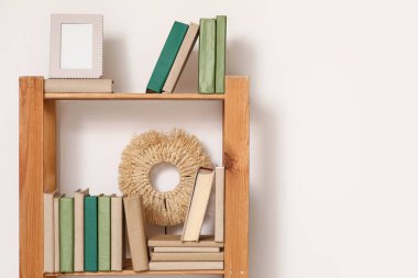 Ev kütüphanesindeki ışık duvarının yanındaki ahşap kitaplık.