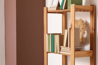 Ev kütüphanesindeki ışık duvarının yanındaki ahşap kitaplık.