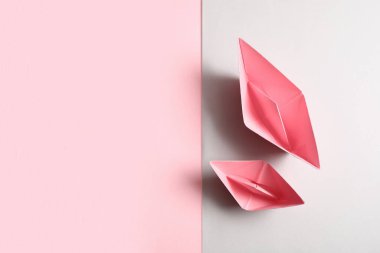 Renkli arkaplanda pembe origami tekneleri