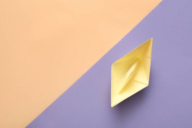 Renkli arkaplanda sarı origami teknesi