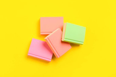 Sarı arkaplan üzerine kitap şeklinde renkli silgiler