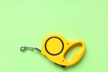 Yeşil arka planda sarı geri çekilebilir köpek tasması