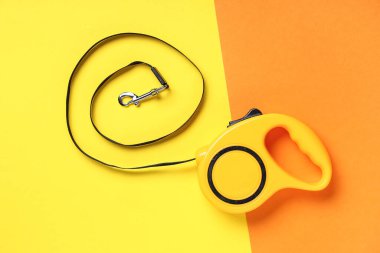 Arka planda kurşun bulunan sarı geri çekilebilir köpek tasması