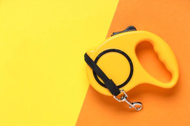 Arka planda kurşun bulunan sarı geri çekilebilir köpek tasması