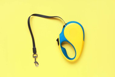 Sarı arka planda kurşun ile geri çekilebilir köpek tasması