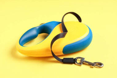 Sarı arka planda kurşun ile geri çekilebilir köpek tasması