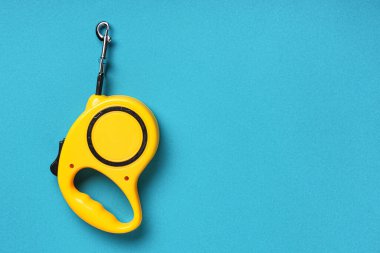 Mavi arka planda sarı geri çekilebilir köpek tasması