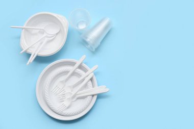 Pembe arka planda plastik sofra takımı ve çatal bıçaklı kompozisyon