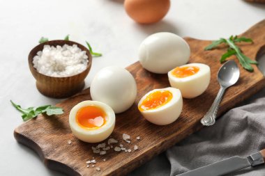 Kaynamış yumurta ve roka yapraklı ahşap tahta.