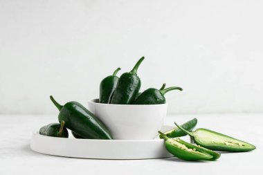 Beyaz arka planda yeşil biberli tabak ve tabak.