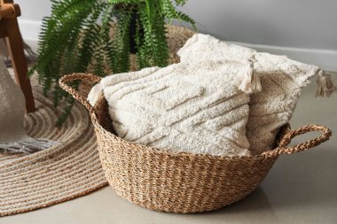 Oturma odasında yastıklı sepet.