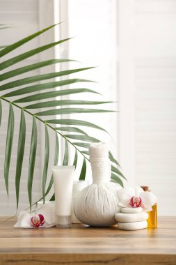 Kozmetik ürünleri, spa aksesuarları ve ahşap masa üzerinde orkide çiçekleri olan kompozisyon