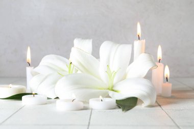 Güzel zambak çiçekleri ve yanan mumlar.