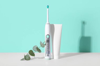 Diş macunu ve okaliptüs arkaplan üzerine elektrik diş fırçası.