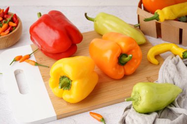 Beyaz arka planda farklı taze biberli ahşap tahta.