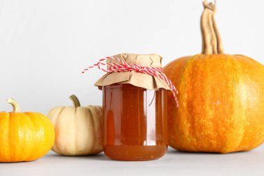 Beyaz arka planda bal kabağı reçeli kavanozu