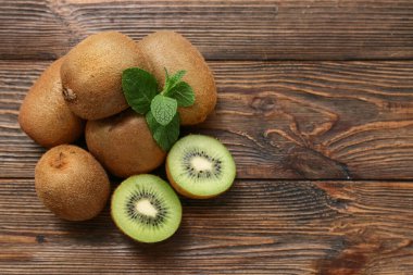 Taze kivi ve ahşap zemin üzerinde nane.