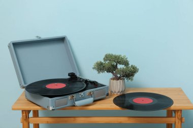 Odadaki mavi duvarın yanındaki masada CD çalar var.