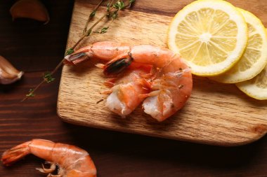 Lezzetli kaynamış karides ve ahşap zemin üzerinde limon.