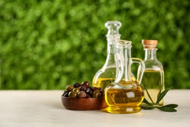 Dışarıdaki beyaz masada süprüntüler ve bir şişe taze zeytinyağı.