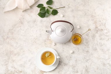 Bir fincan lezzetli ıhlamur çayı ve beyaz grunge arka planda yapraklar.