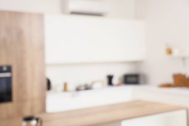 Beyaz tezgahlı ve yemek masalı aydınlık mutfağın bulanık görüntüsü