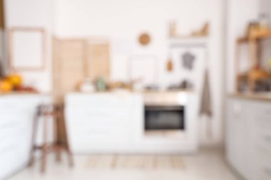 Beyaz tezgah ve raf üniteli açık mutfak bulanık görünüyor.