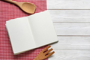 Boş tarif defteri, peçete ve ahşap çatal bıçak takımı.