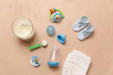 Beslenme şişesi, bebek sütü formülü ve renk arka planında aksesuarlar