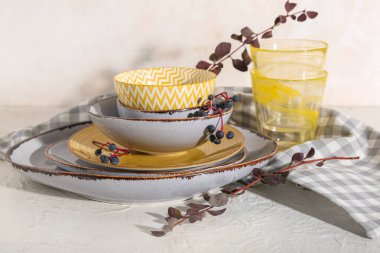 Masada beyaz arka planda sonbahar dalları olan tabak yığını