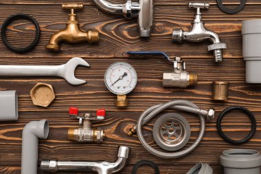 Ahşap arka planda tesisatçı malzemeleri olan kompozisyon