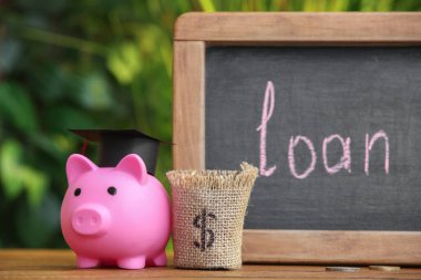 Kelime kredisiyle döşeme tahtası, domuz kumbarası ve çuval açık masa, yakın plan.