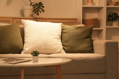 Gri kanepesi ve kahve masası olan şık bir oturma odası.