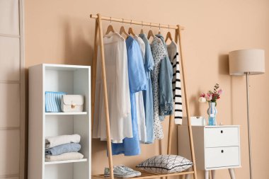 Giysi askısı, raf ünitesi ve tuvalet masası olan şık bir soyunma odası.