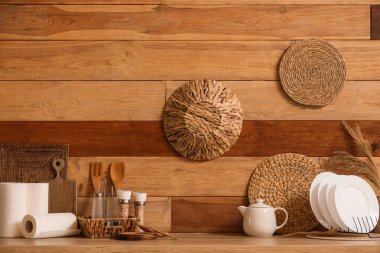 Kitchen utensils on counter near wooden wall