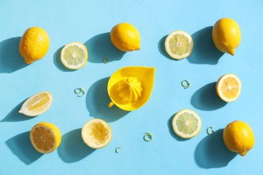 Mavi arka planda limon ve sıkacağı olan kompozisyon