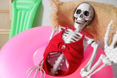 Yatak odasında yüzme yüzüğü olan insan iskeleti. Yaz tatili kavramı