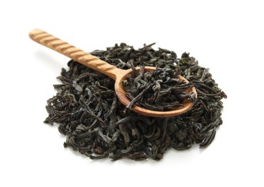 Beyaz arka planda kuru siyah çay yaprakları ile ahşap kaşık.