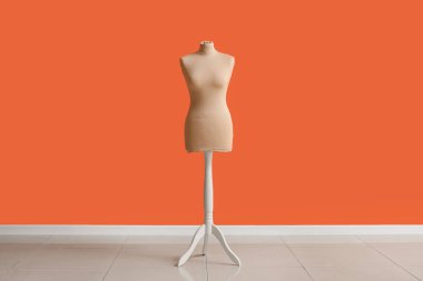 Turuncu duvarın yanındaki terzi için manken