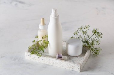 Beyaz grunge arka planda mermer tepsi, şişe ve dereotu kozmetik ürünleri kavanozu ile kompozisyon, yakın plan