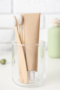 Banyodaki masanın üzerinde diş fırçası olan cam bardak, yakın plan.