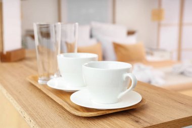 Süslü otel odasındaki ahşap masada çay tepsisi, yakın plan.