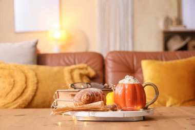 Balkabaklı latte ile kruvasan ve parlayan ışıklar odada, yakın plan.